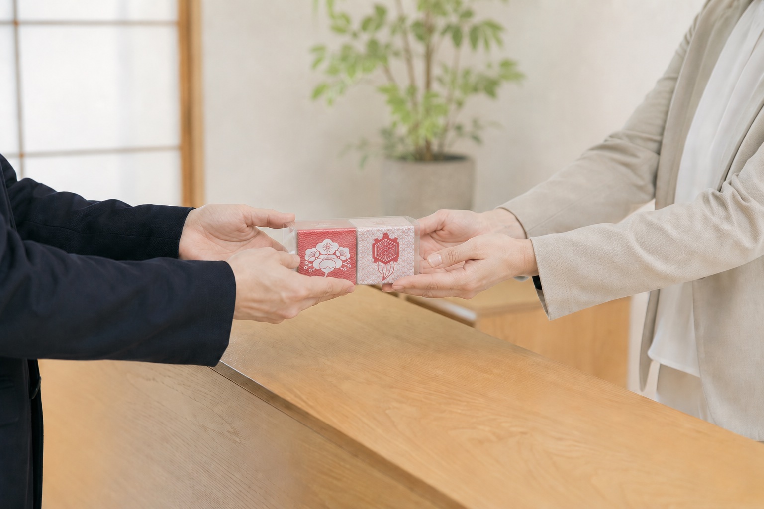 法人の訪問先で箱茶の透明カートンセットを両手で手渡す様子
